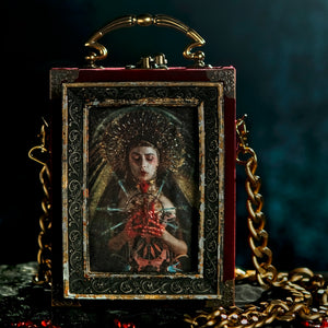 Cartera Virgen de los dolores enmarcada sobre terciopelo rojo