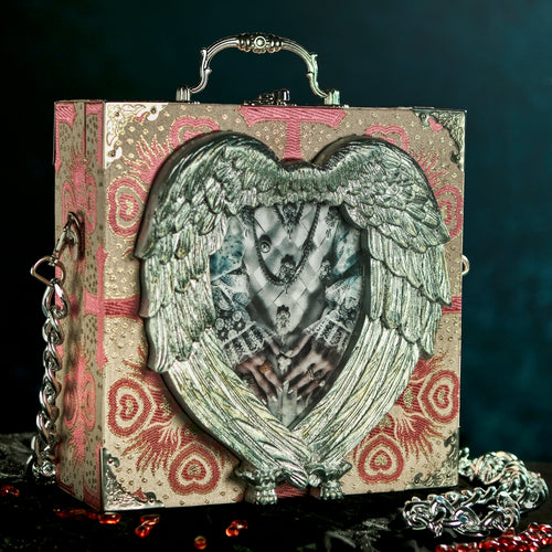 Elizabeth's hands in a hand carved heart frame hand bag