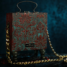 Load image into Gallery viewer, Framed resin nose on red and cyan brocade hand bag