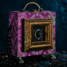 Load image into Gallery viewer, Framed raven head on purple and silver brocade hand bag