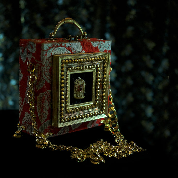 Framed Cage on red brocade hand bag